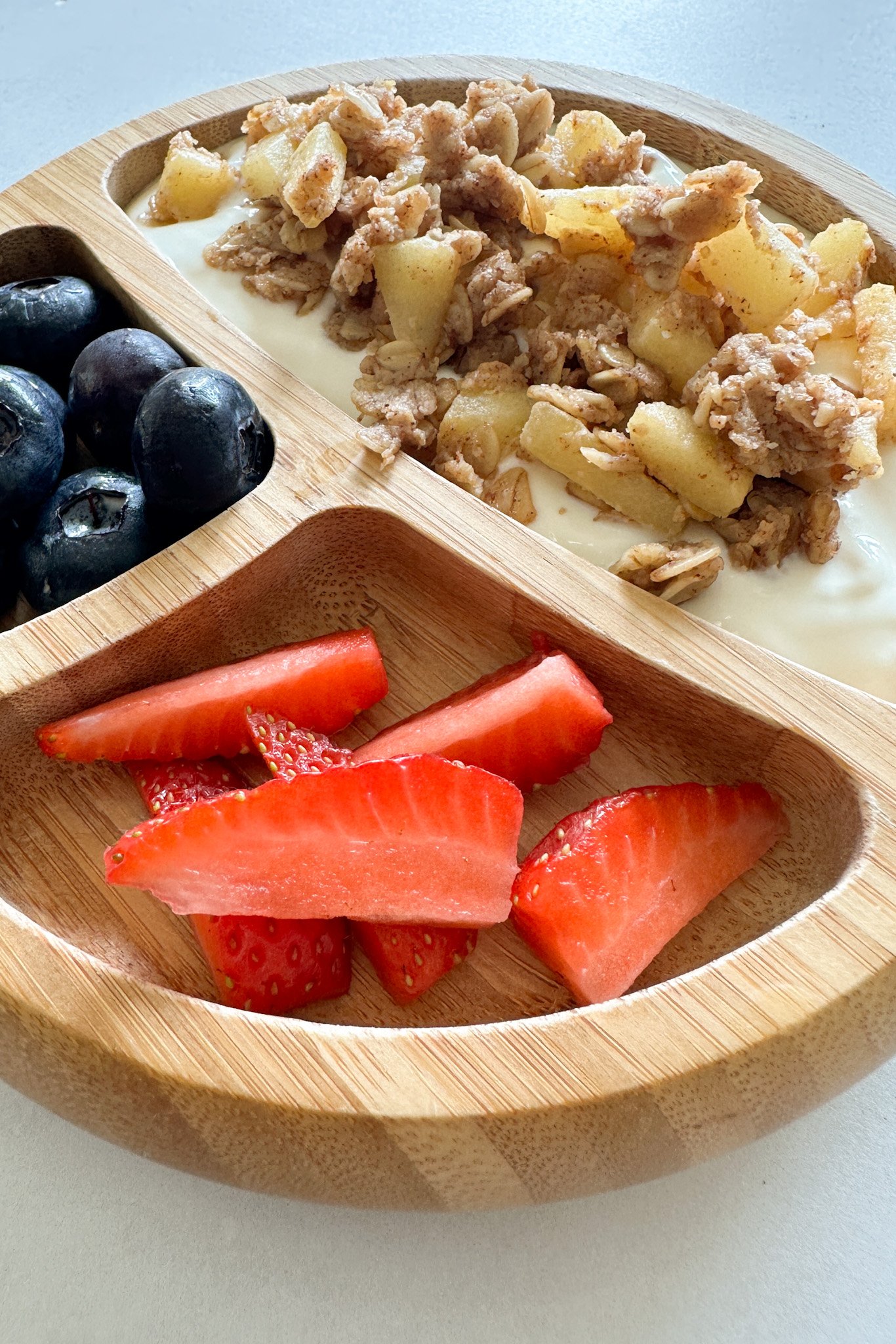 Apple crisp served with yogurt and berries.