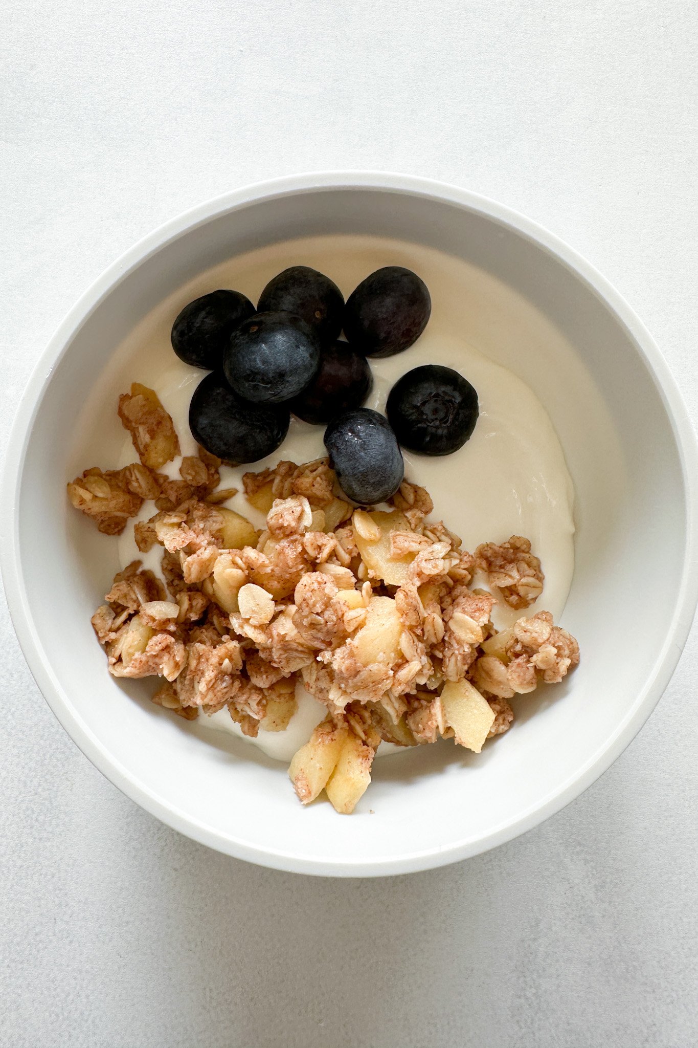 Apple crisp served with yogurt and berries.