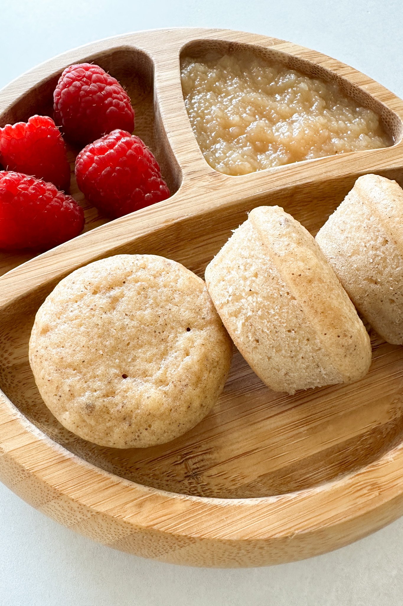 Apple donut muffins served with raspberries and applesauce.