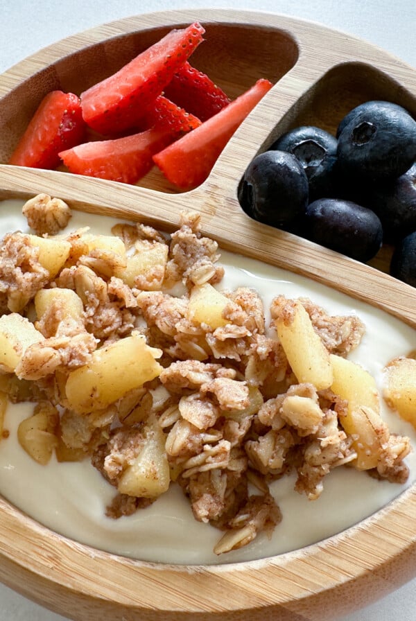 Apple crisp served with yogurt and berries.