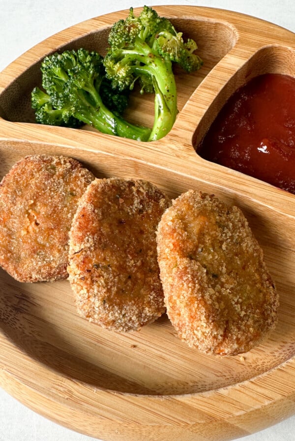 Veggie chicken nuggets served with broccoli and ketchup.