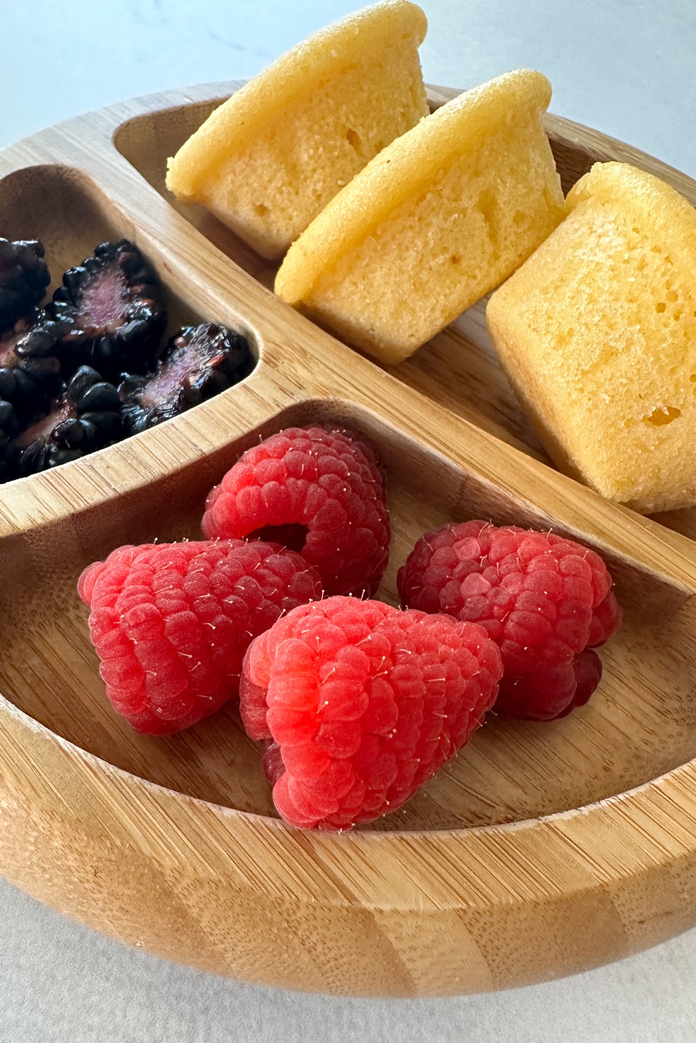 Mini cornbread muffins served with berries.
