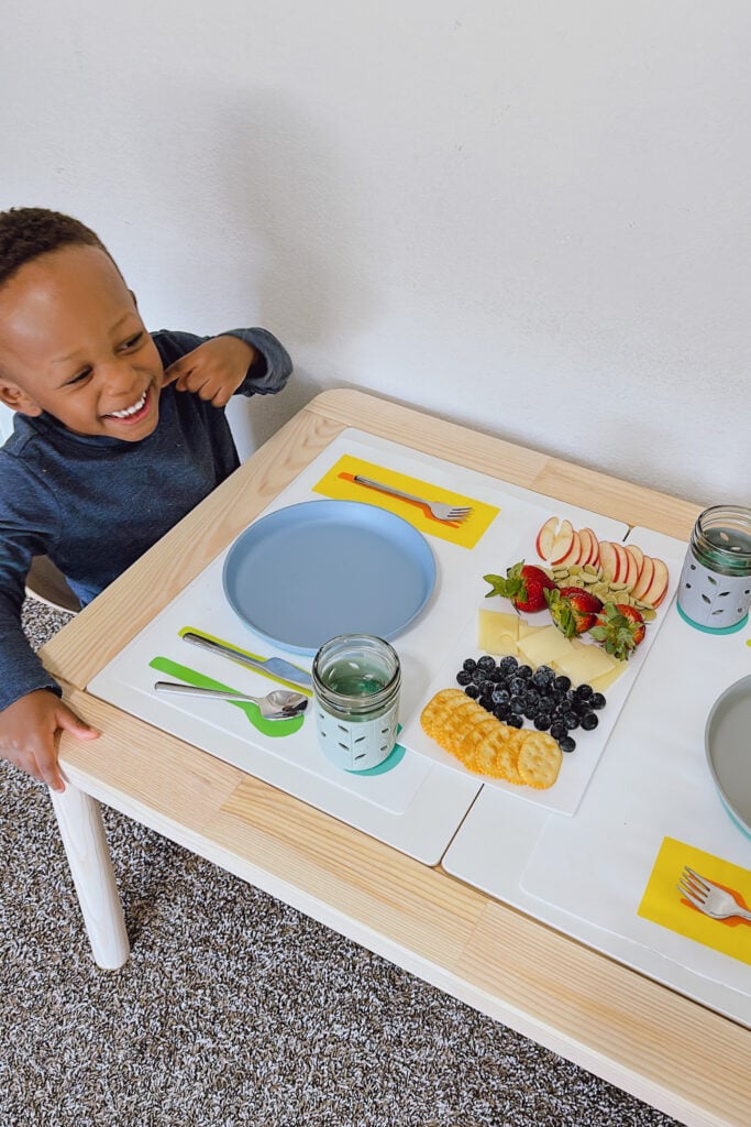 Toddler boy eating with Lovevery placemat.