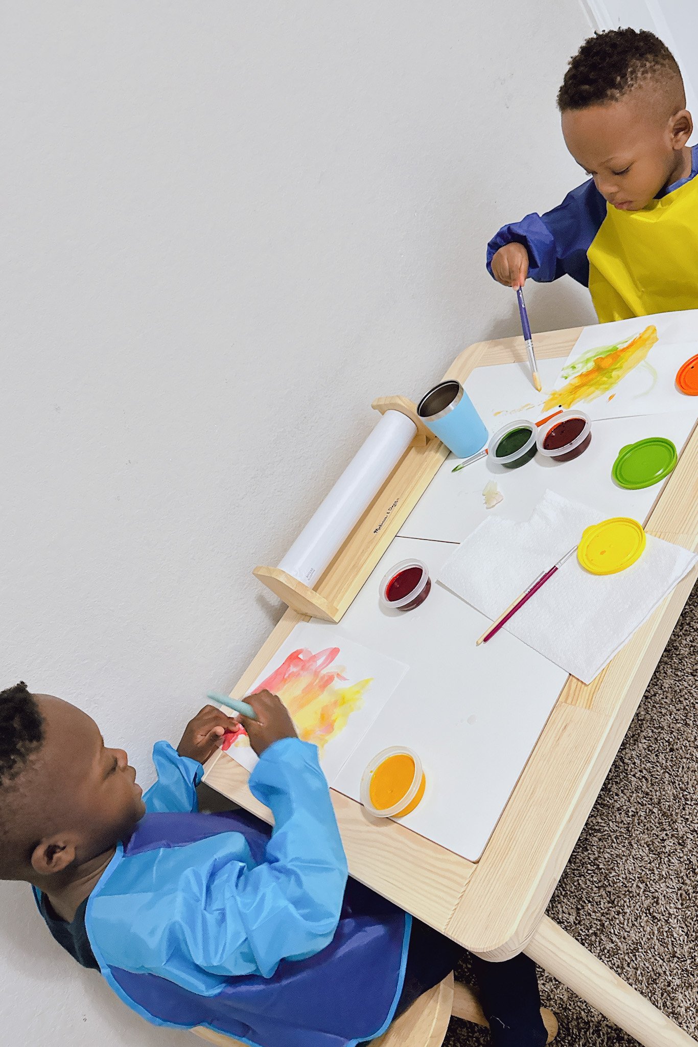 Toddler boys painting on Ikea Flisat table.