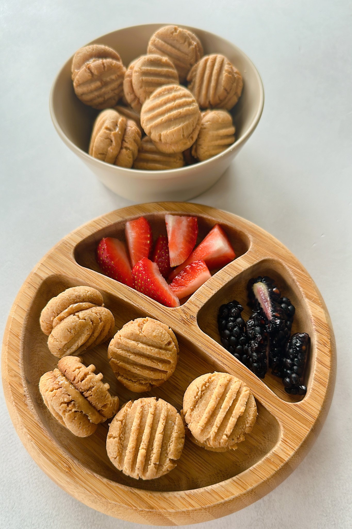 Peanut butter cookies served with blackberries and strawberries.