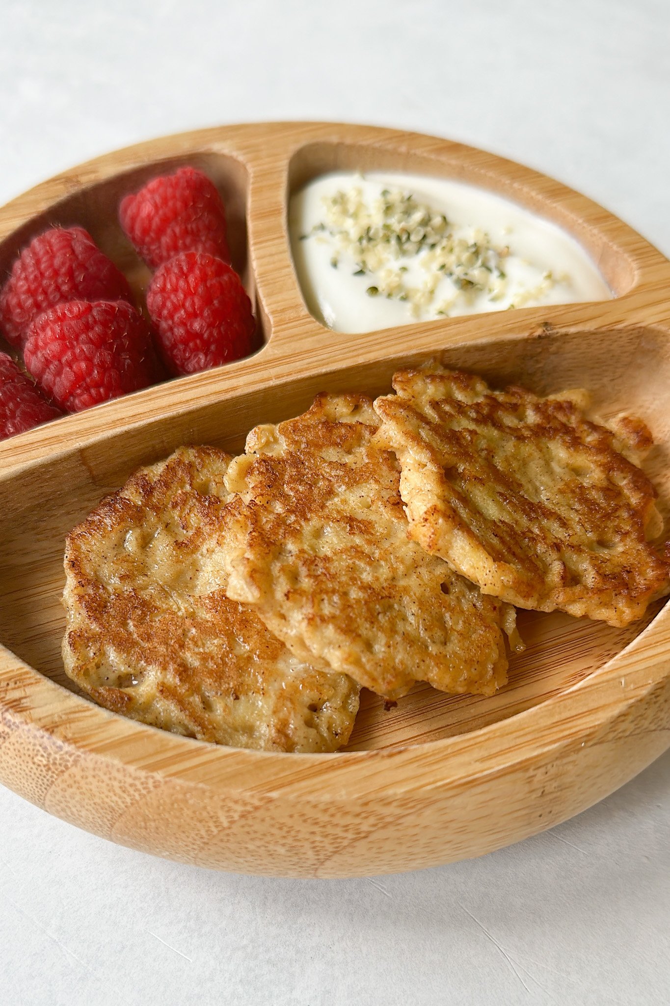 Cinnamon apple fritters served with raspberries and yogurt.