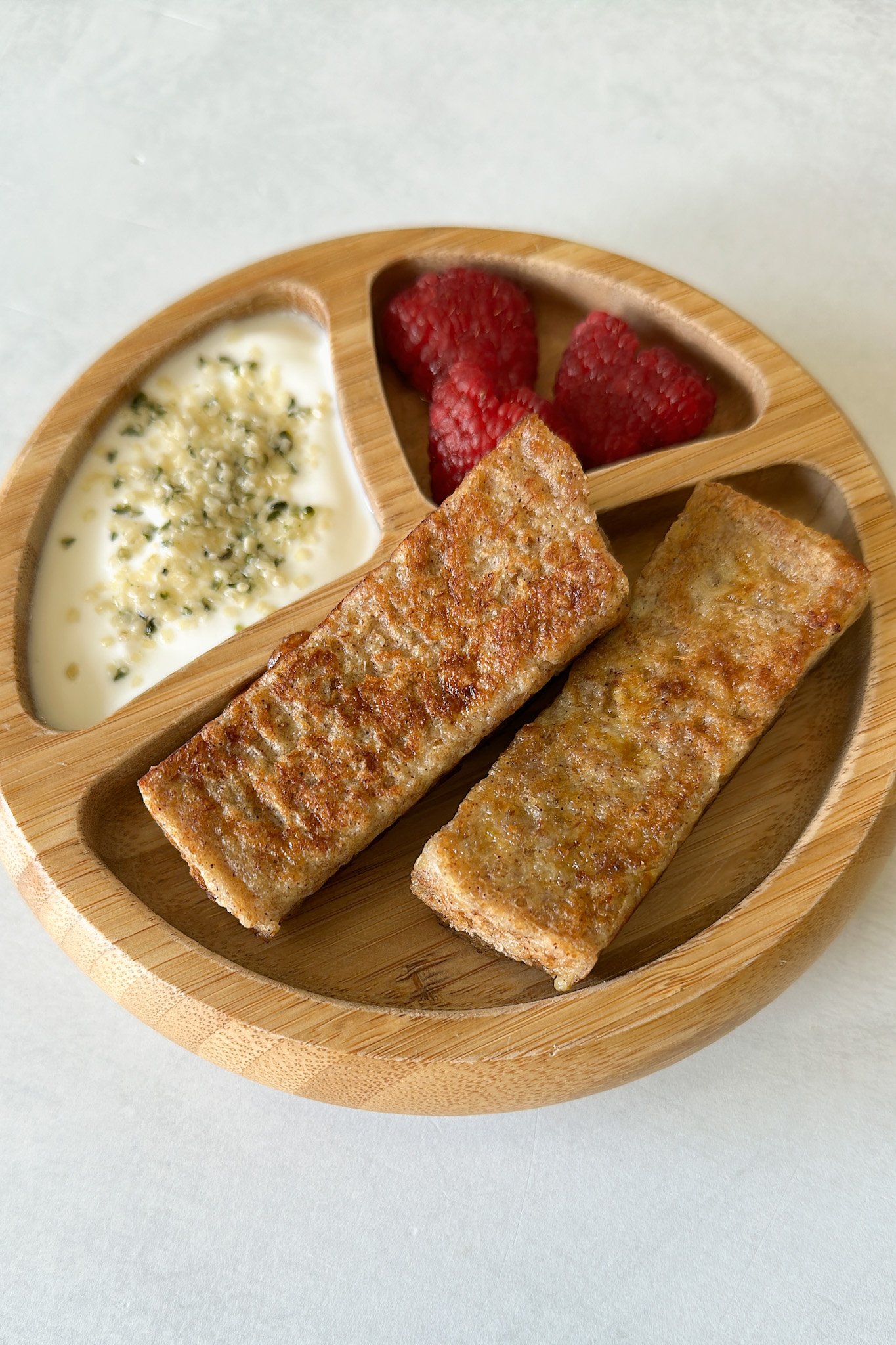 Peanut butter and banana French toast sticks served with yogurt and raspberries.