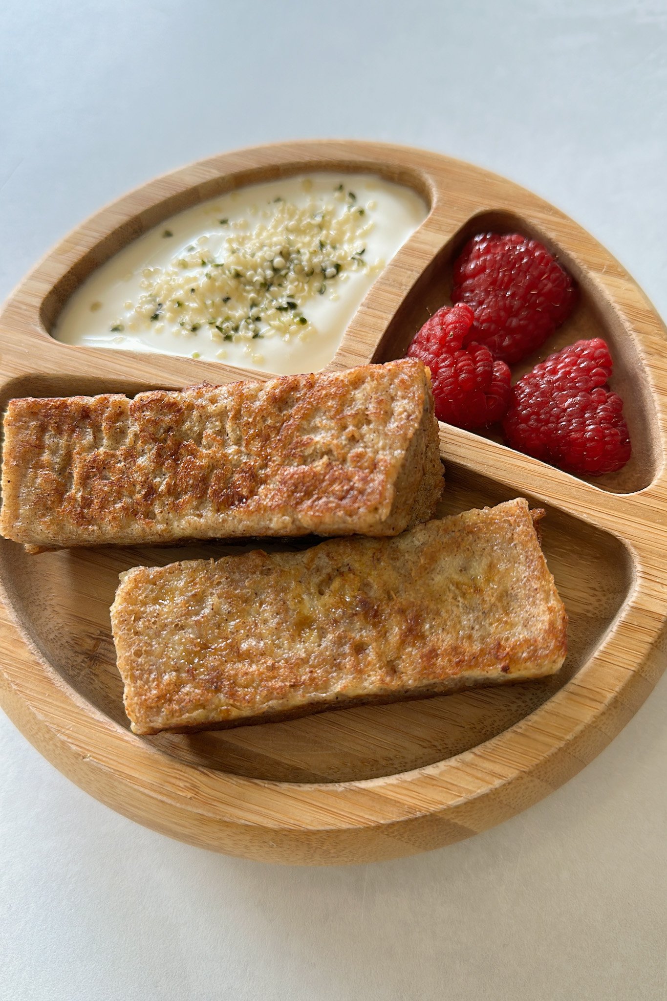 Peanut butter and banana French toast sticks served with yogurt and raspberries.