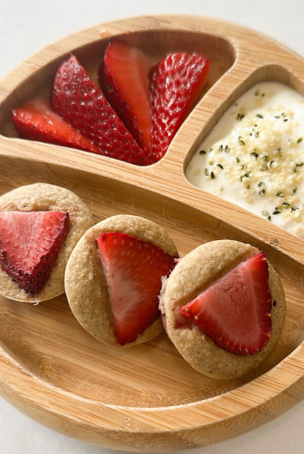 Strawberry banana oatmeal muffins served with strawberries and yogurt.