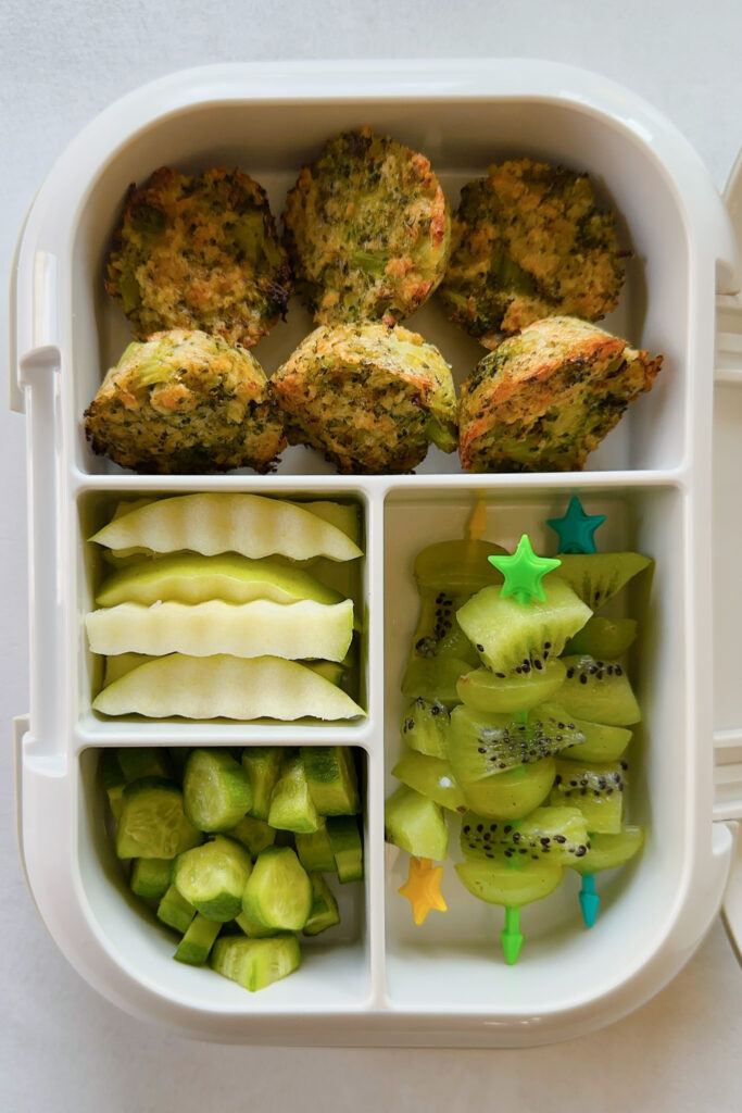 Broccoli bites served with grape and kiwi, apples, and cucumbers.