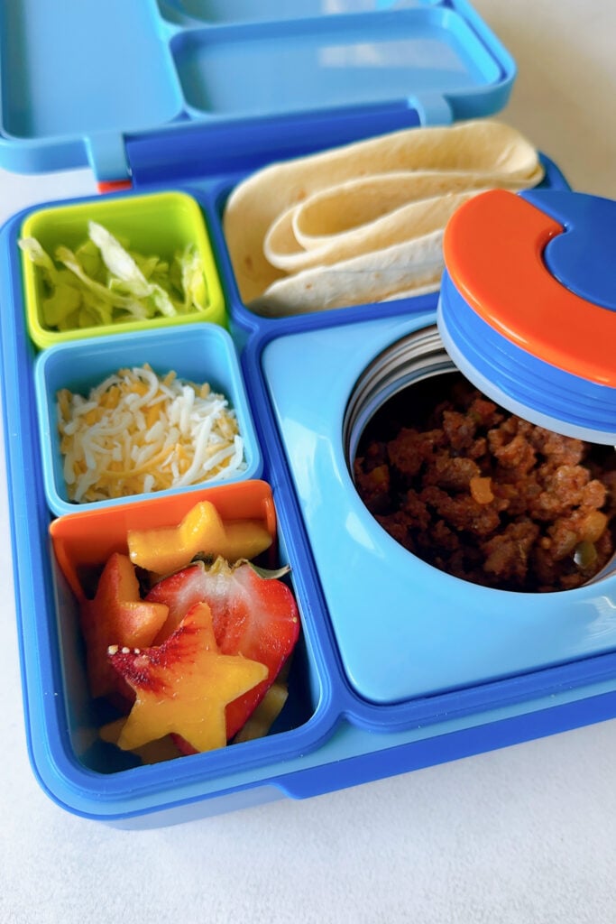 Ground beef, tortillas, lettuce, cheese, and strawberries and tomatoes.