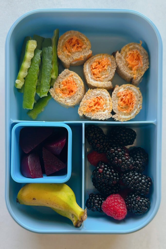 Carrot cream cheese rollups served with cucumbers, blackberries, raspberries, mini banana, and diced beets.
