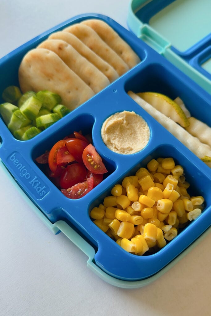 Naan dippers served with hummus, cucumber, tomatoes, corn, and pears.