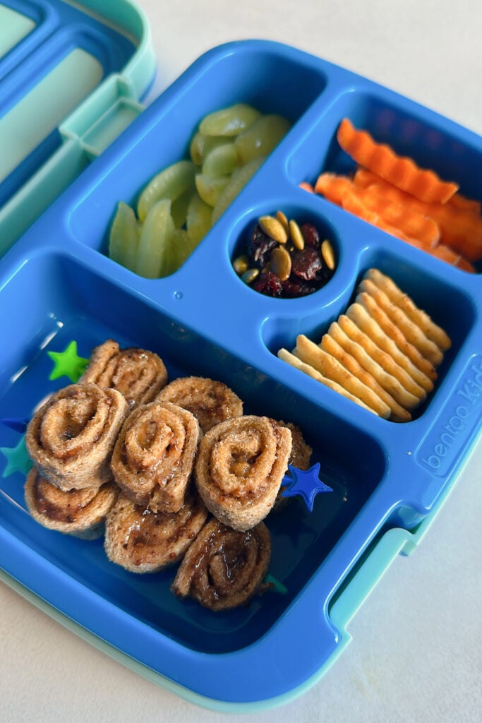 Peanut butter and jelly rollups served with grapes, carrots, crackers, pumpkin seeds and dried cranberries.