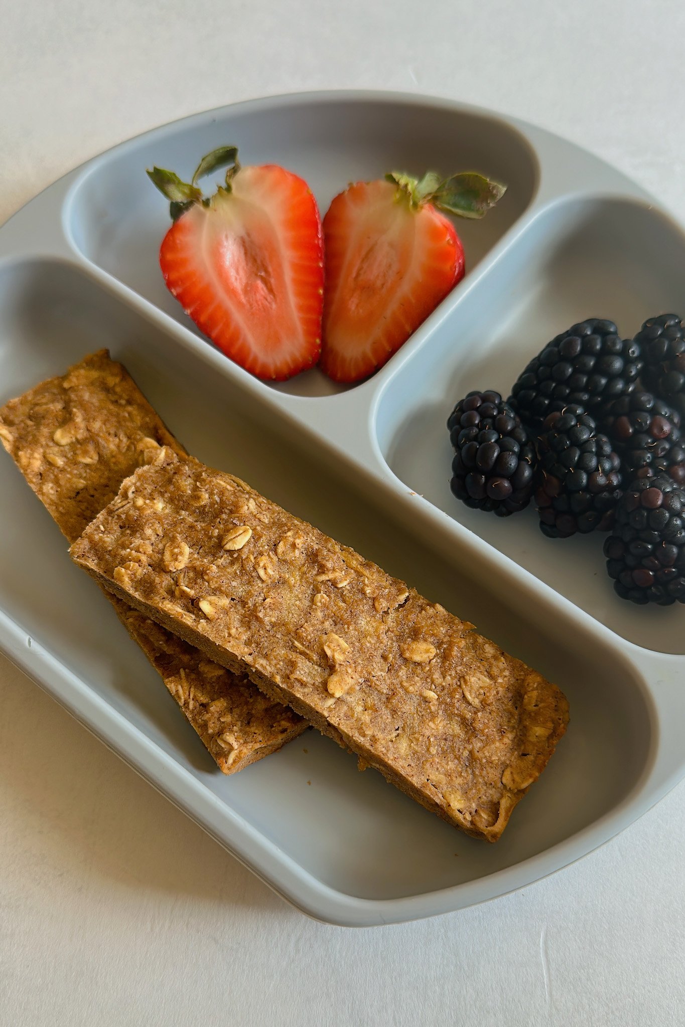 Cinnamon apple oatmeal bars served with strawberries and blackberries.