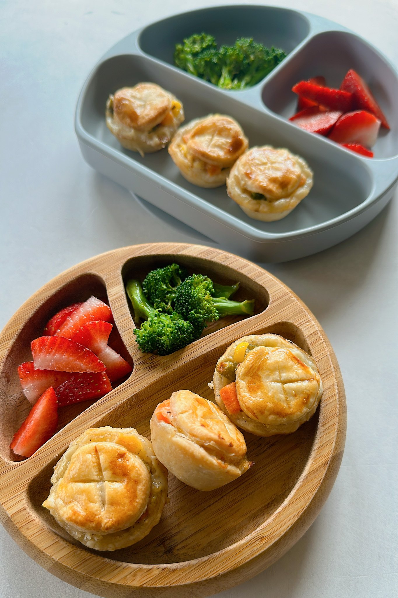 Mini chicken pot pies served with strawberries and broccoli.
