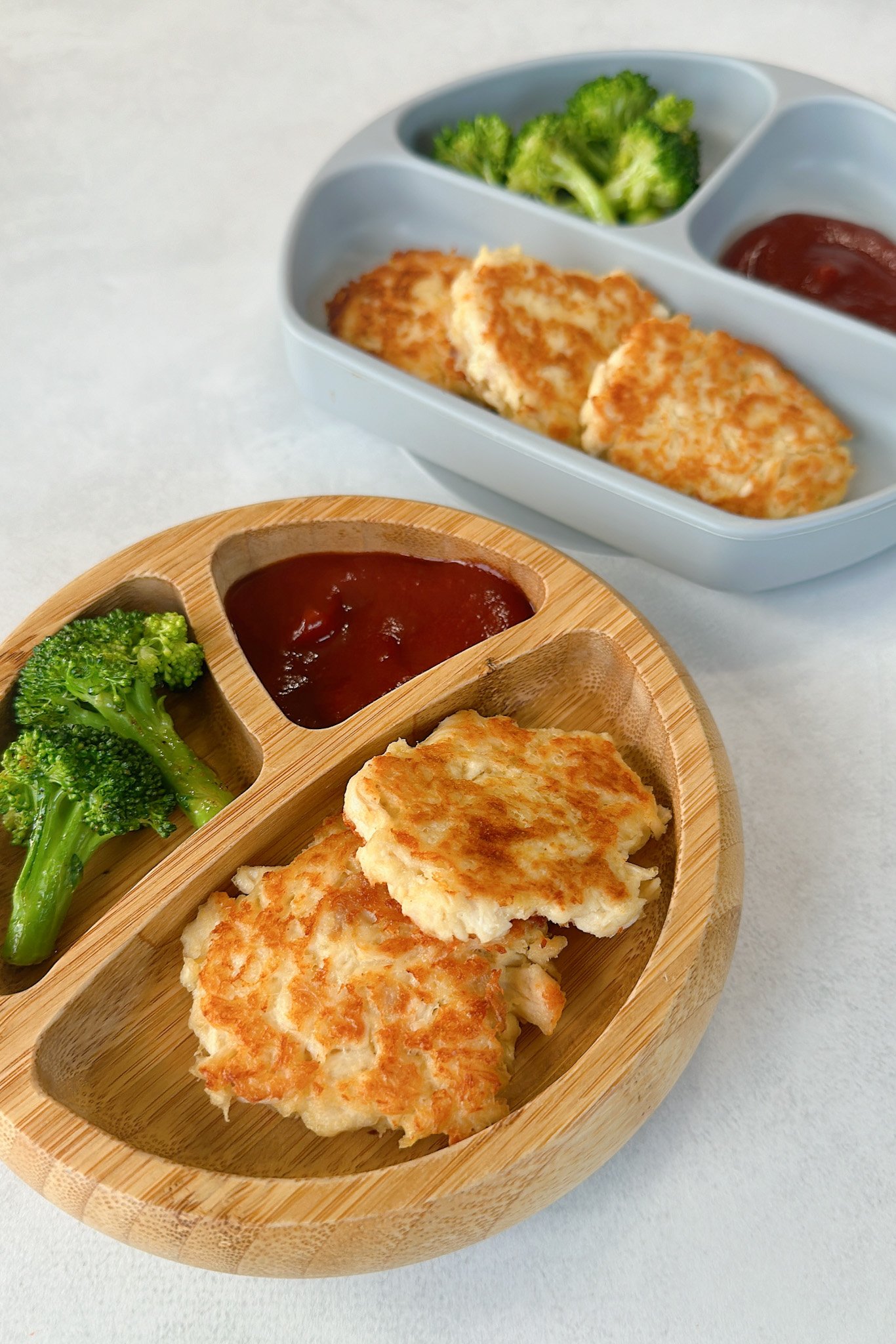 Chicken fritters served with broccoli and ketchup.