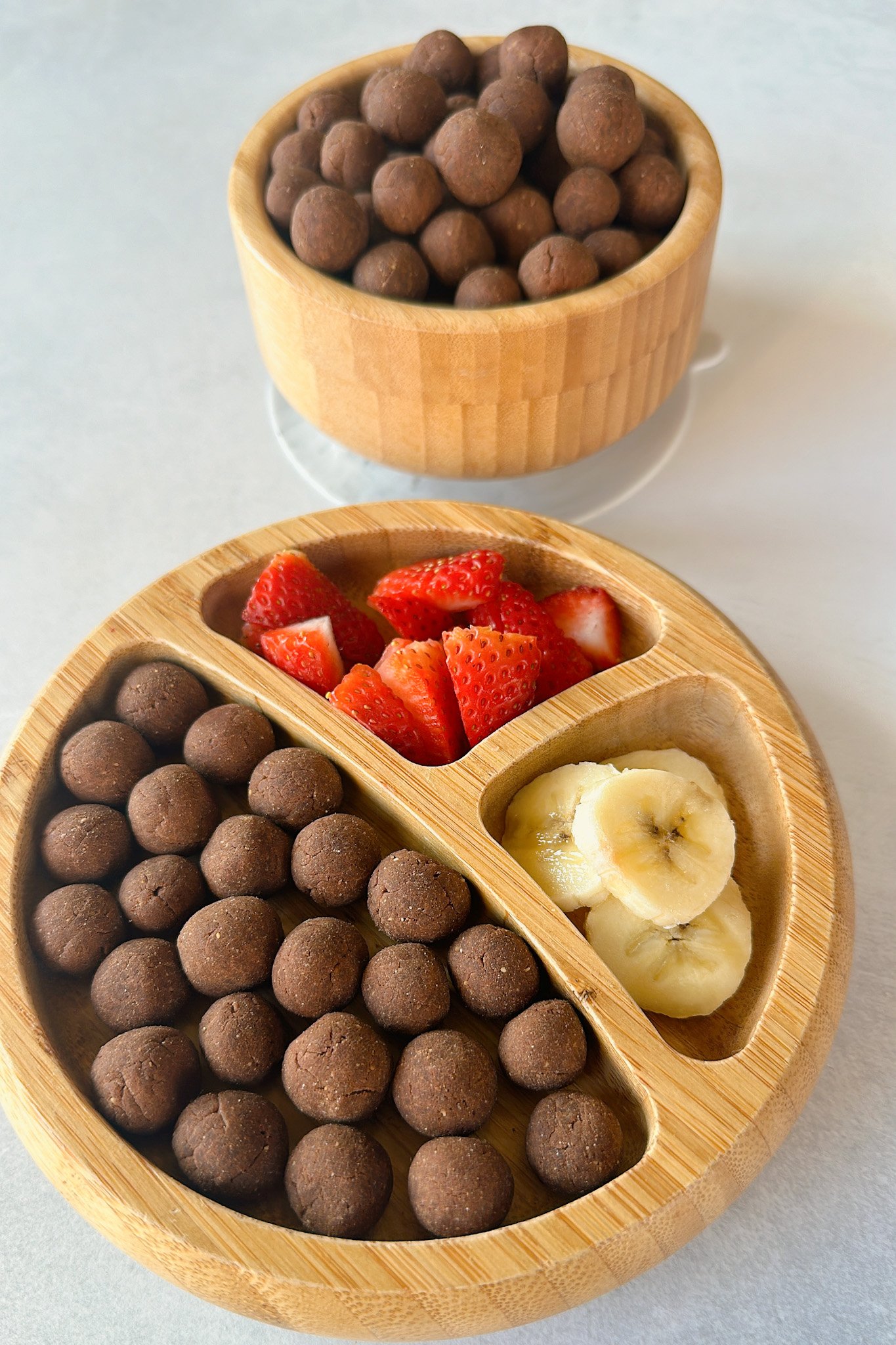 Cocoa puffs cereal served with strawberries and bananas.