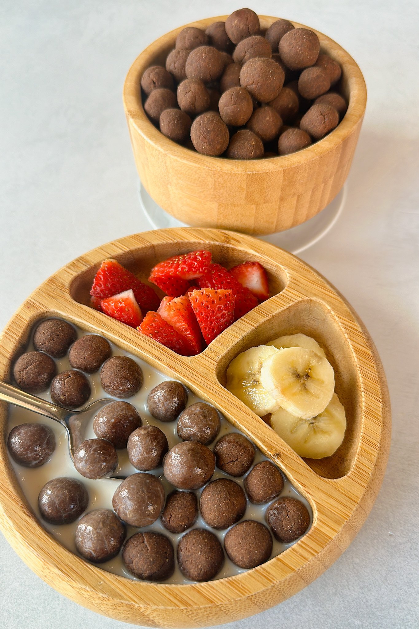 Cocoa puffs cereal served with strawberries and bananas.