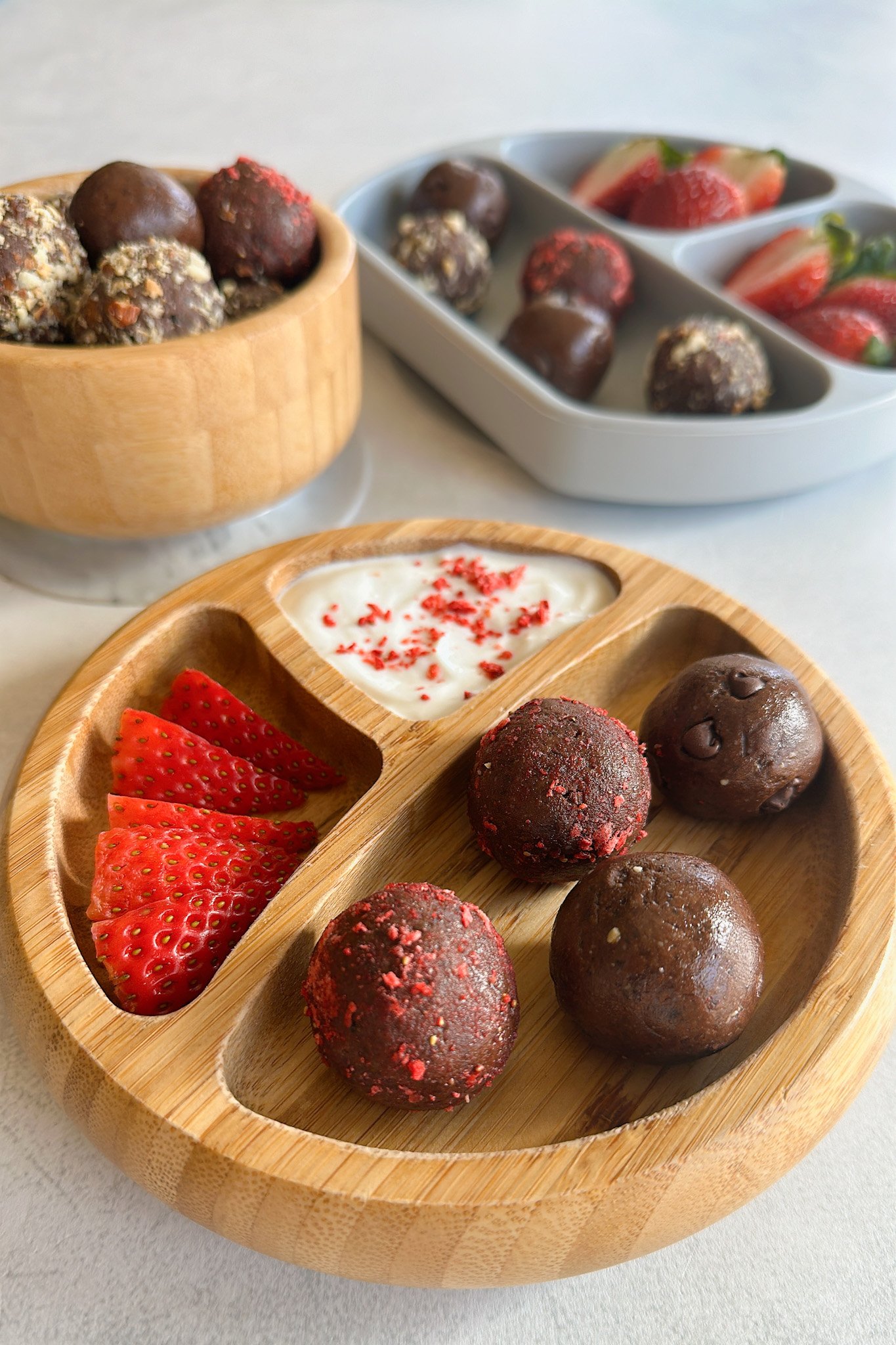 Chocolate balls in a bowl and served with strawberries.