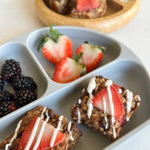 Strawberry banana oat bars served with berries and yogurt.
