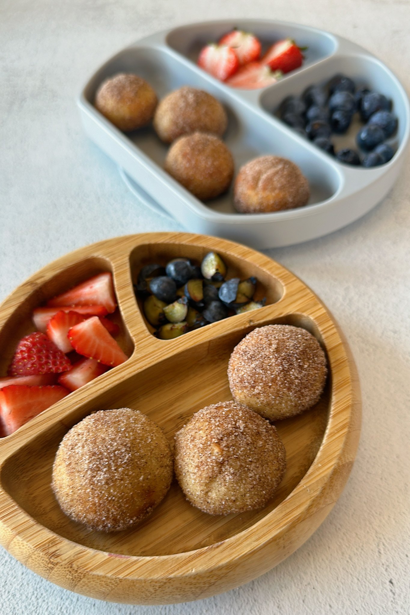 Air fryer donut holes served with strawberries and blueberries.