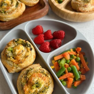 Broccoli and cheese pinwheels served with raspberries and mixed veggies.