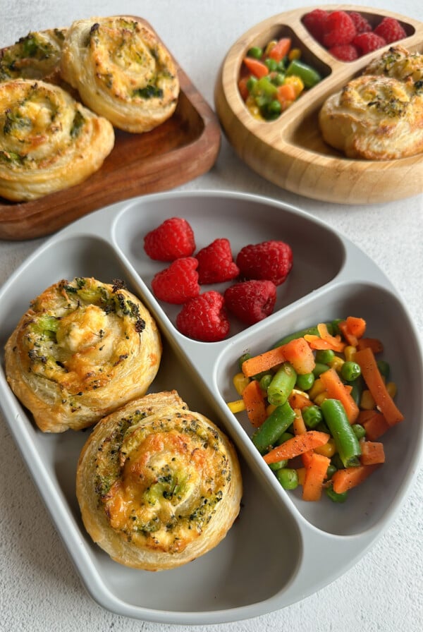 Broccoli and cheese pinwheels served with raspberries and mixed veggies.