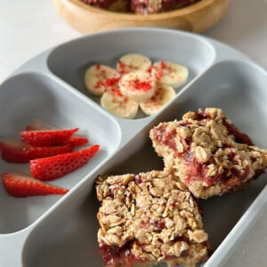 Strawberry crumble bars served with bananas, strawberries, and yogurt.