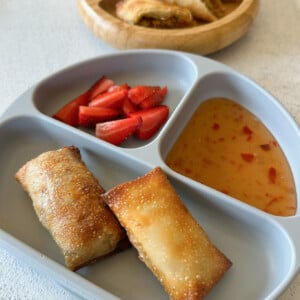 Air fried egg rolls served with sweet chili sauce and strawberries.