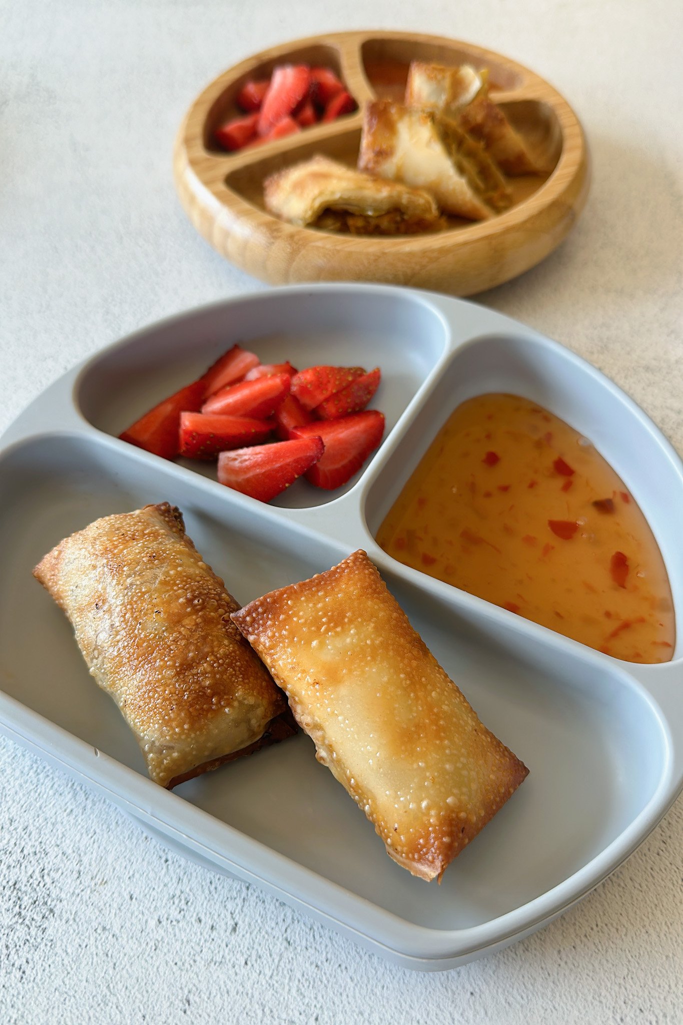 Air fried egg rolls served with sweet chili sauce and strawberries.