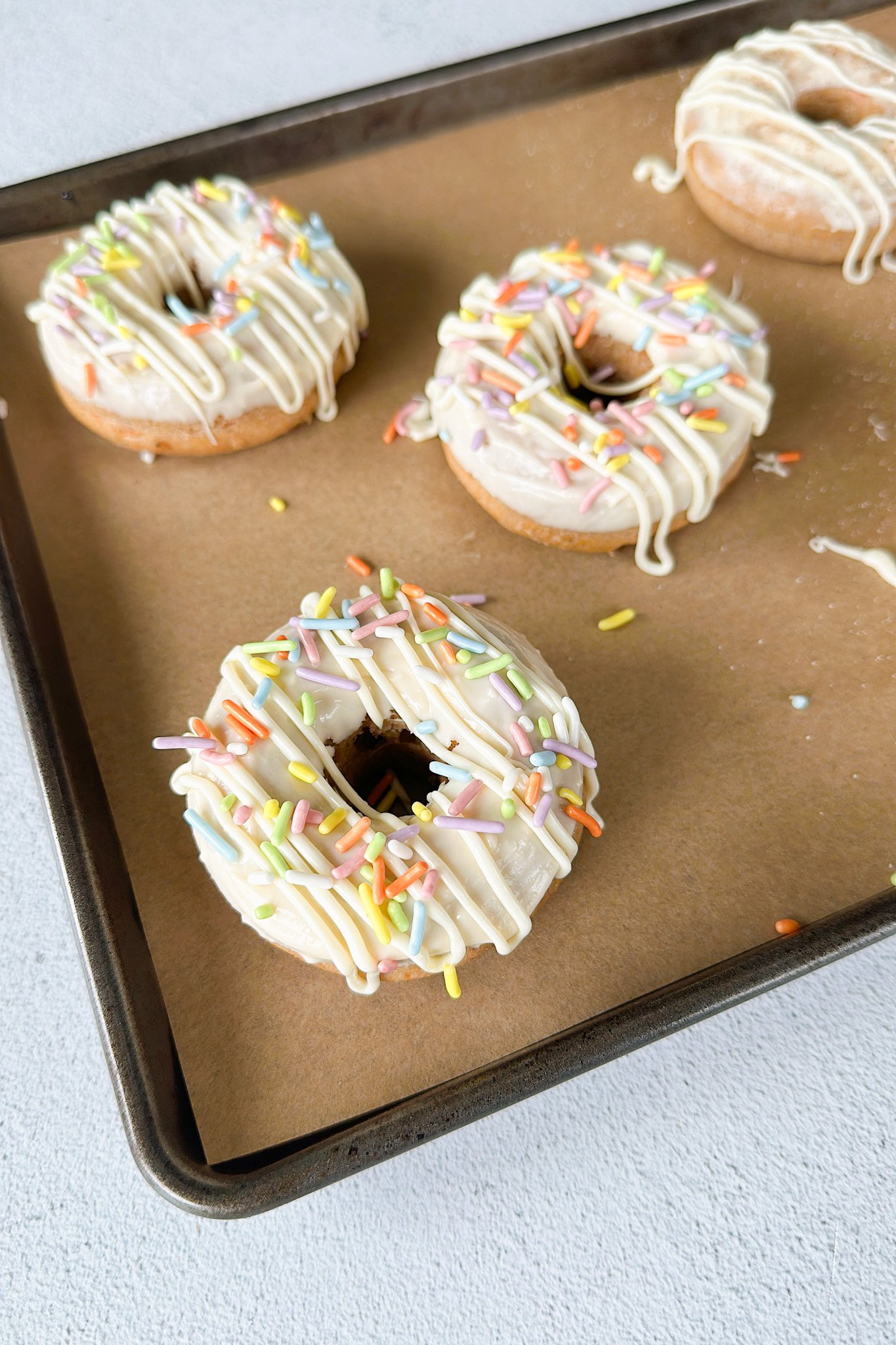 Baked carrot cake donuts on a pan.