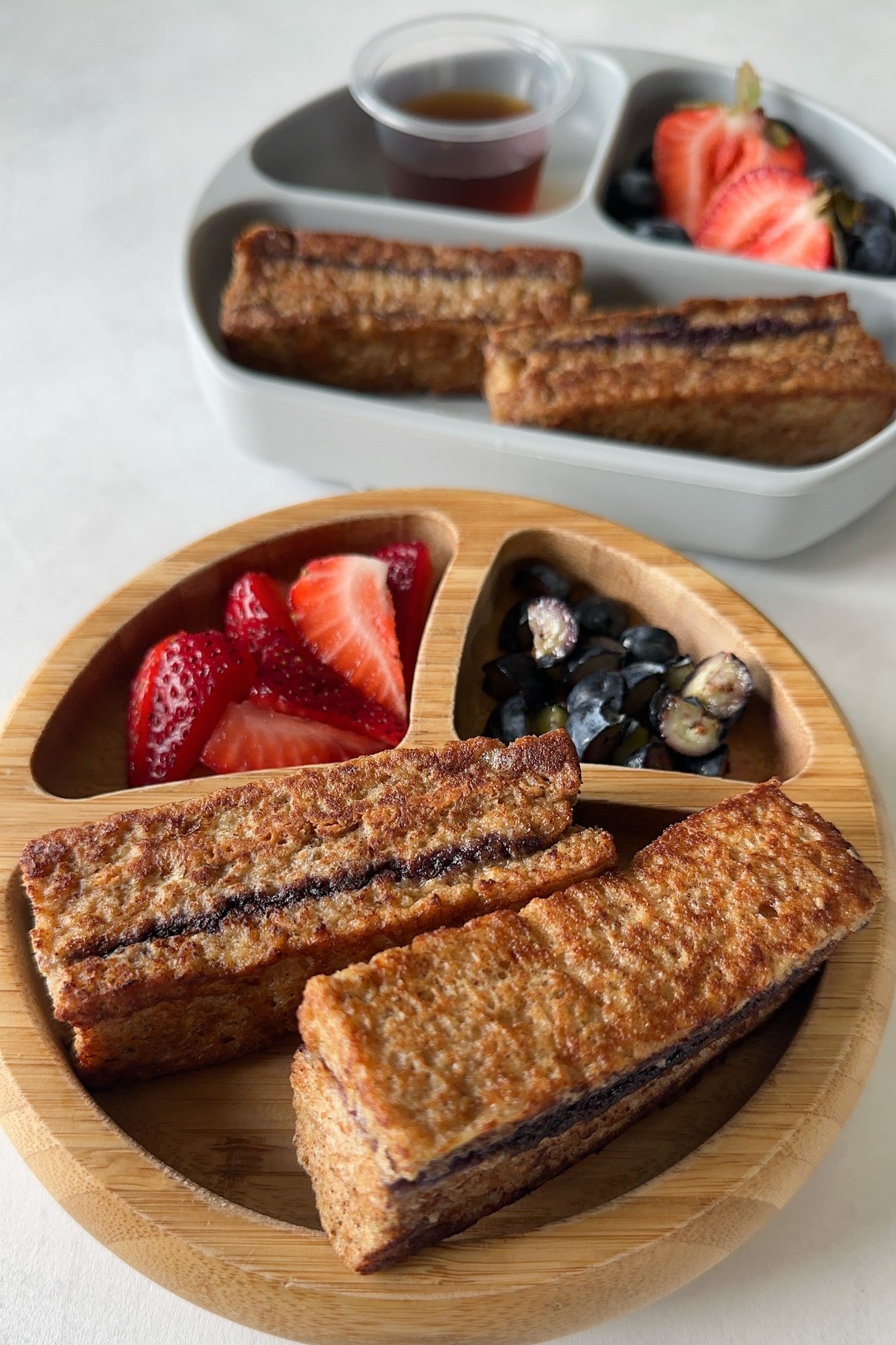 Peanut butter and jelly French toast served with berries and maple syrup.