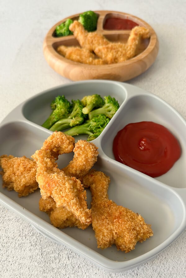 Dino nuggets served with broccoli and ketchup.