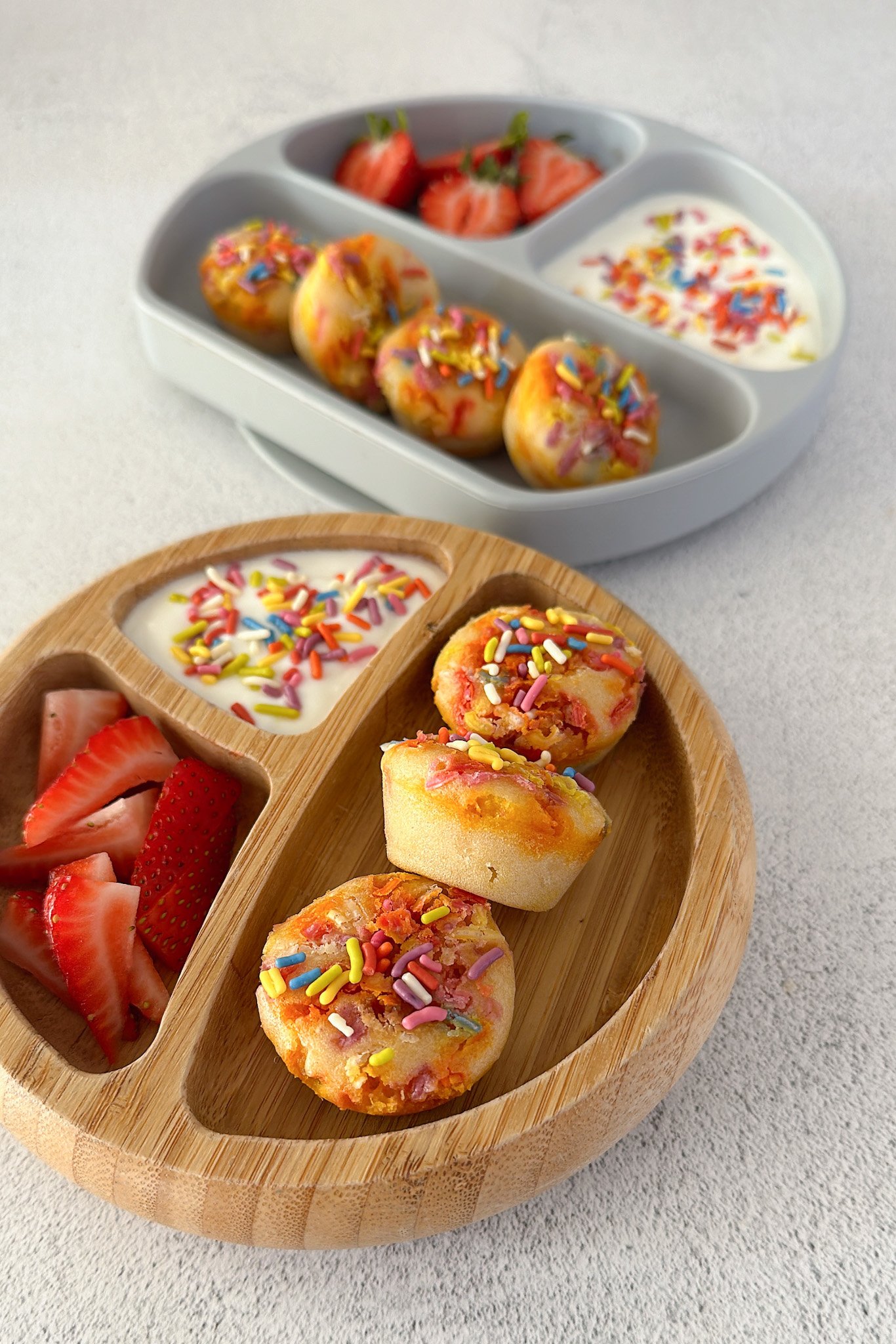 Funfetti muffins served with yogurt and strawberries.