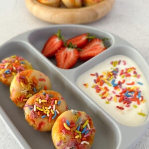 Funfetti muffins served with yogurt and strawberries.