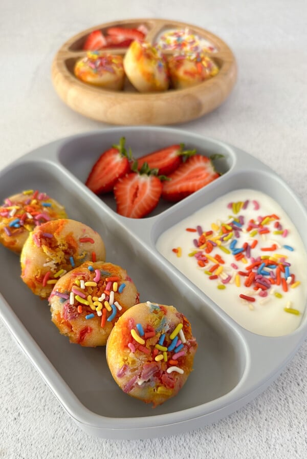 Funfetti muffins served with yogurt and strawberries.