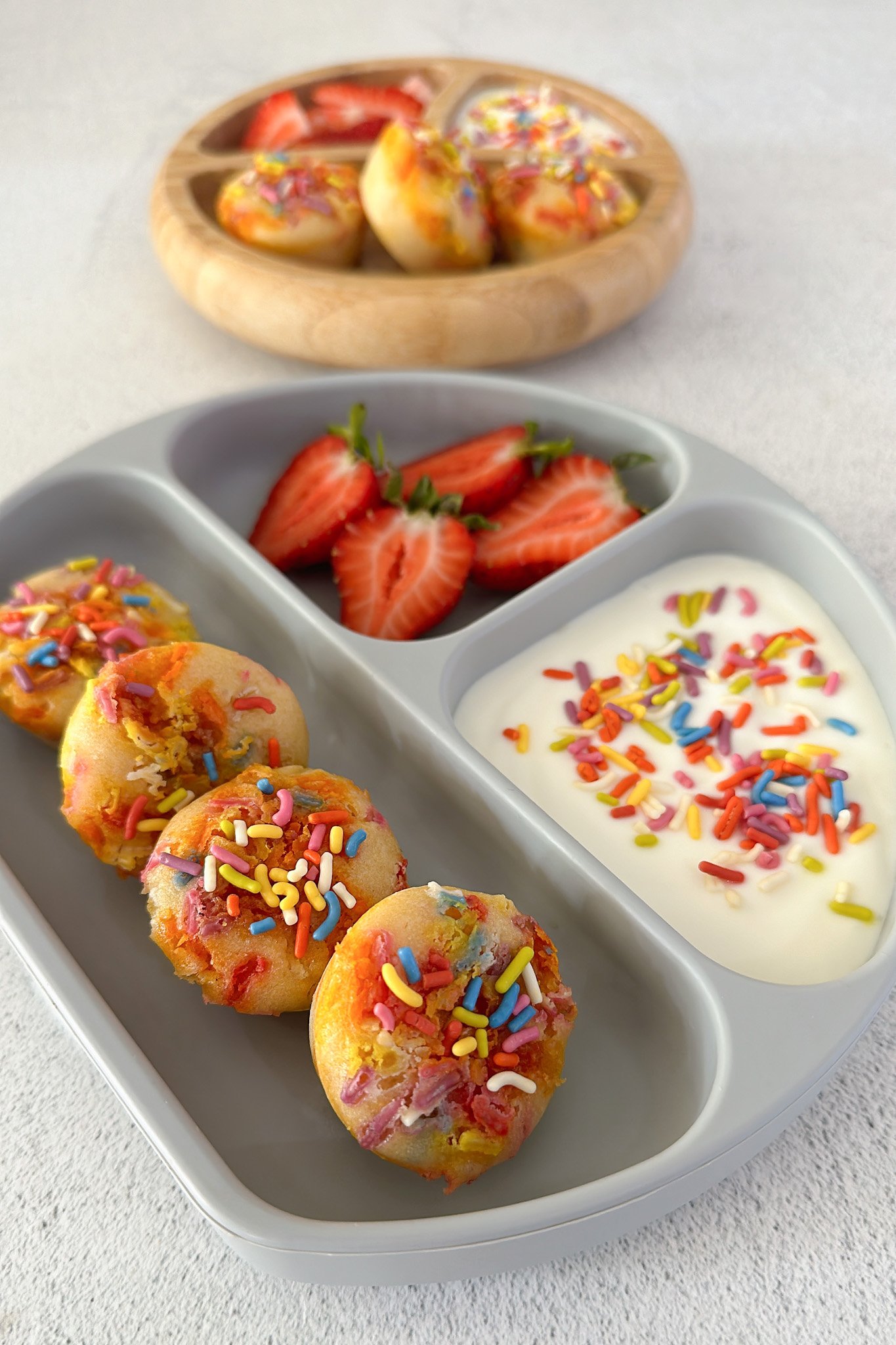 Funfetti muffins served with yogurt and strawberries.