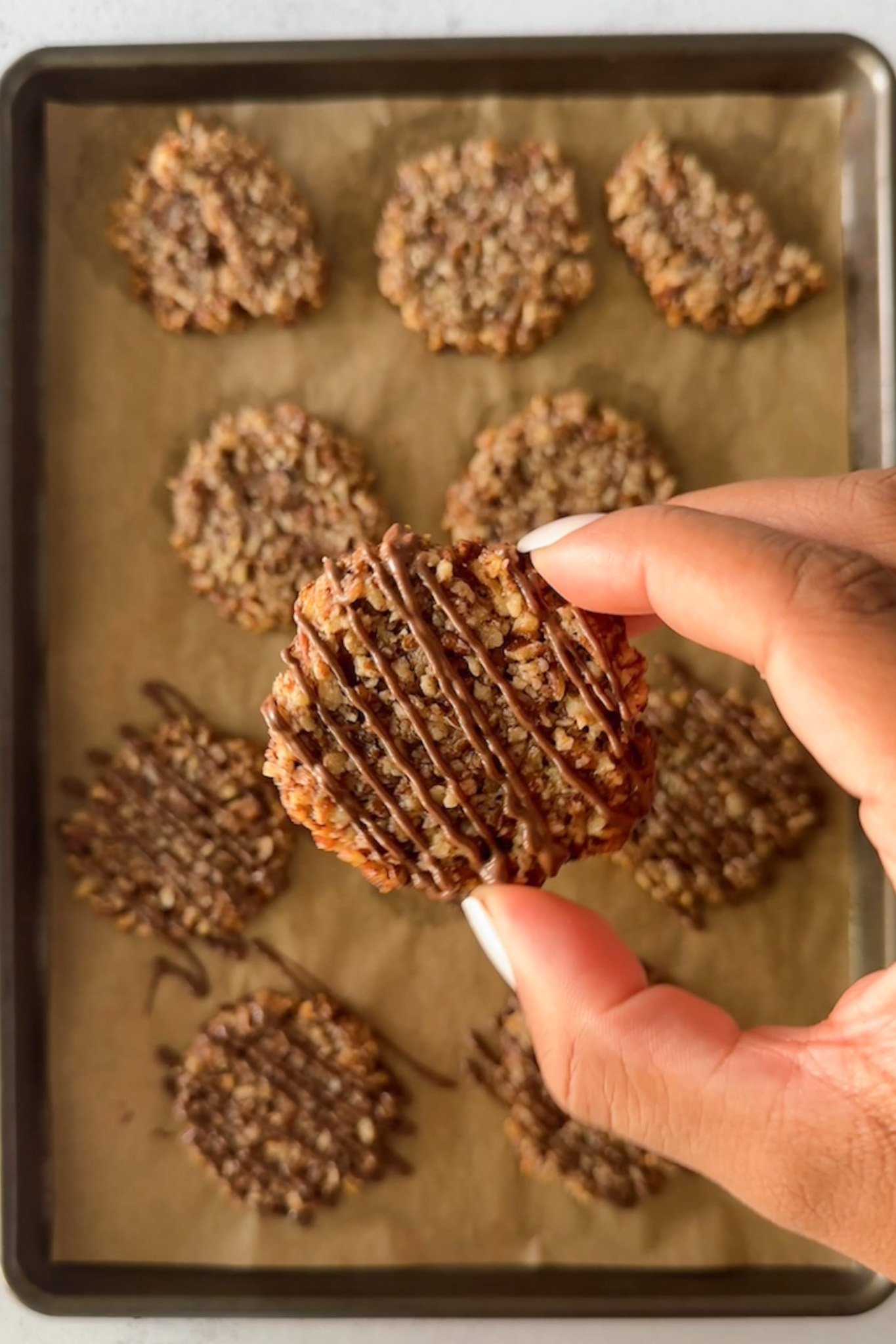 Maple pecan cookies with chocolate drizzled on top.