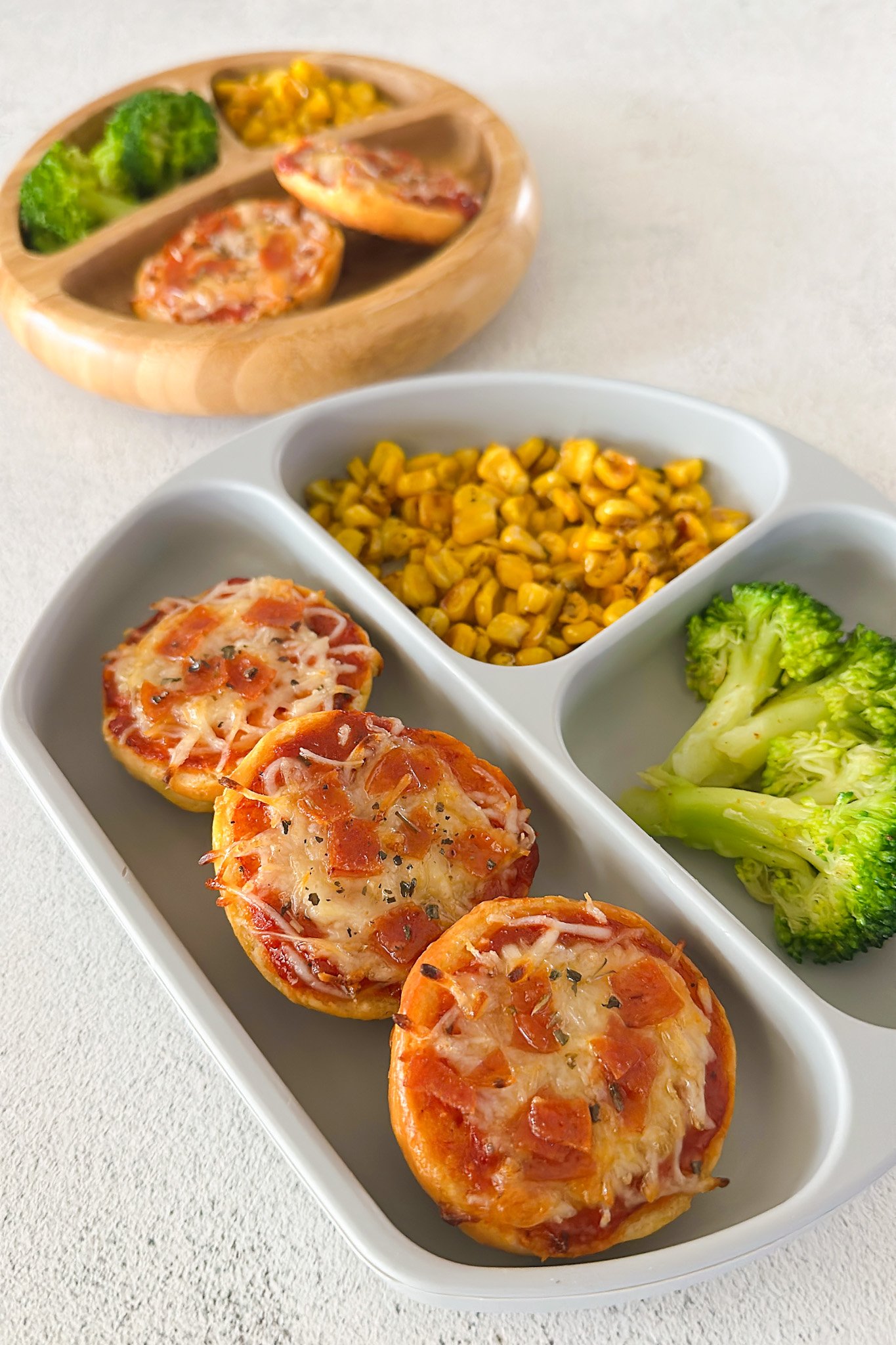 Homemade bagel bites served with corn and broccoli.