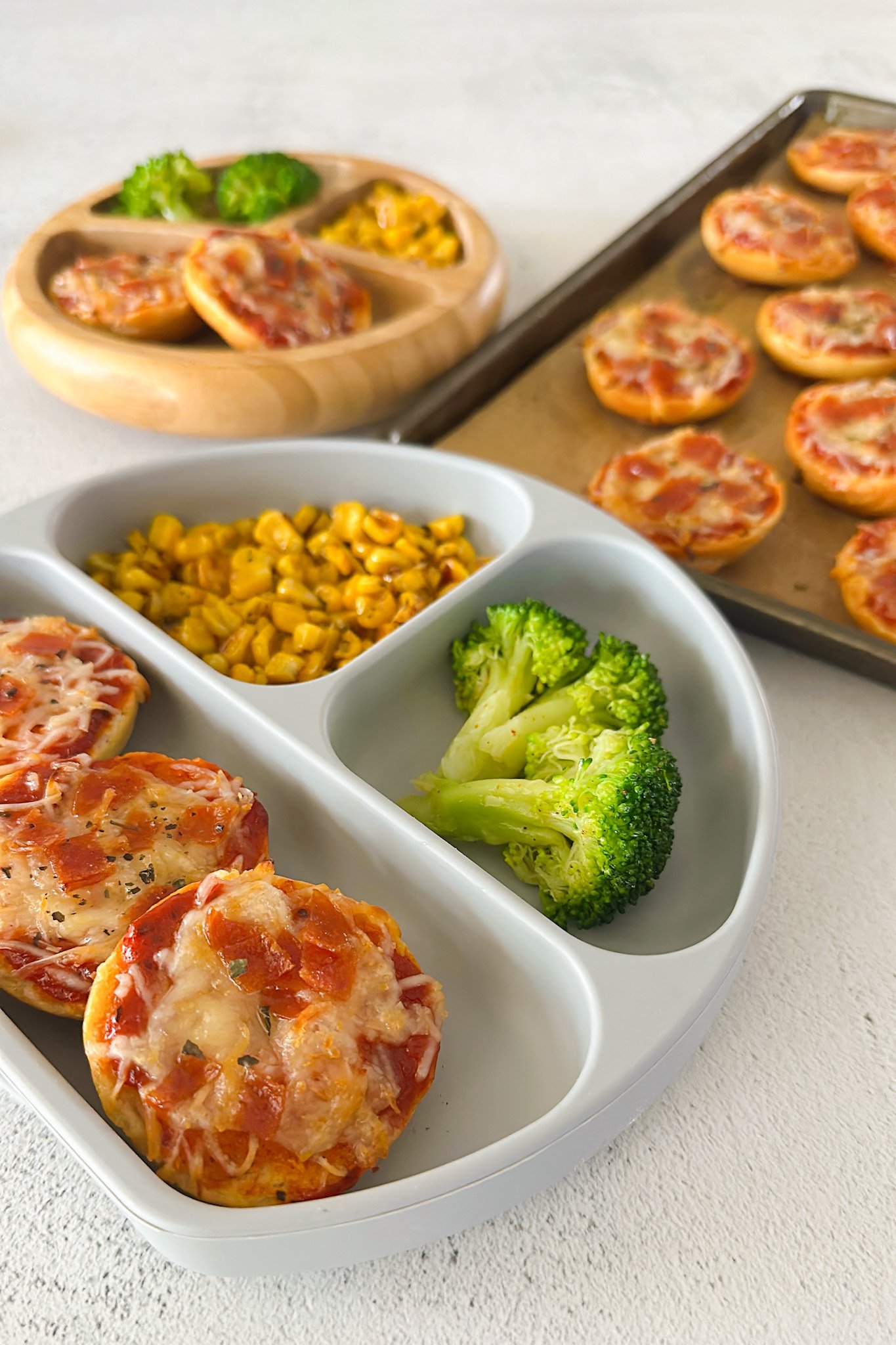 Homemade bagel bites served with corn and broccoli.