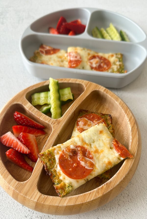 Cheesy zucchini flatbread served with strawberries and cucumbers.