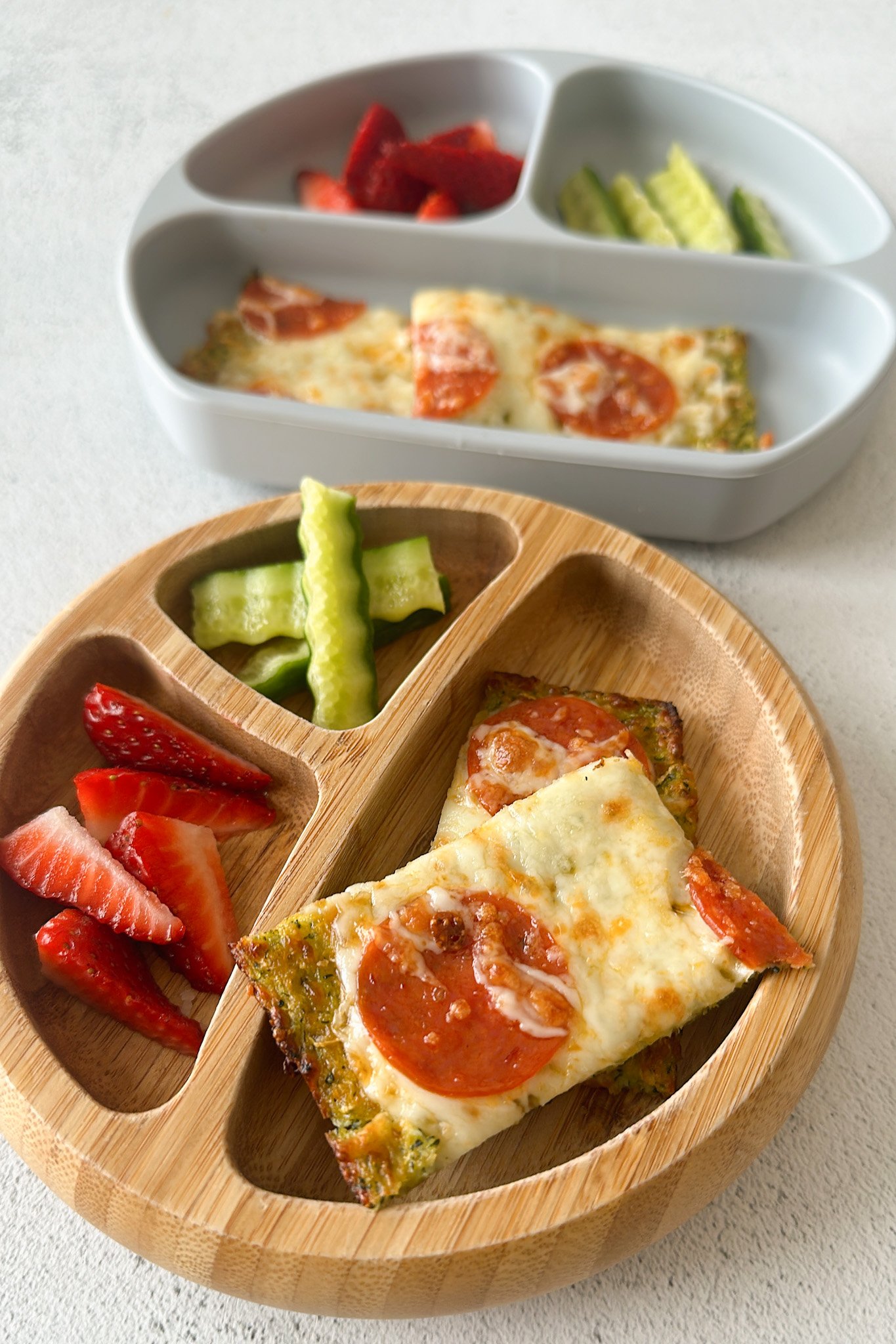 Cheesy zucchini flatbread served with strawberries and cucumbers.