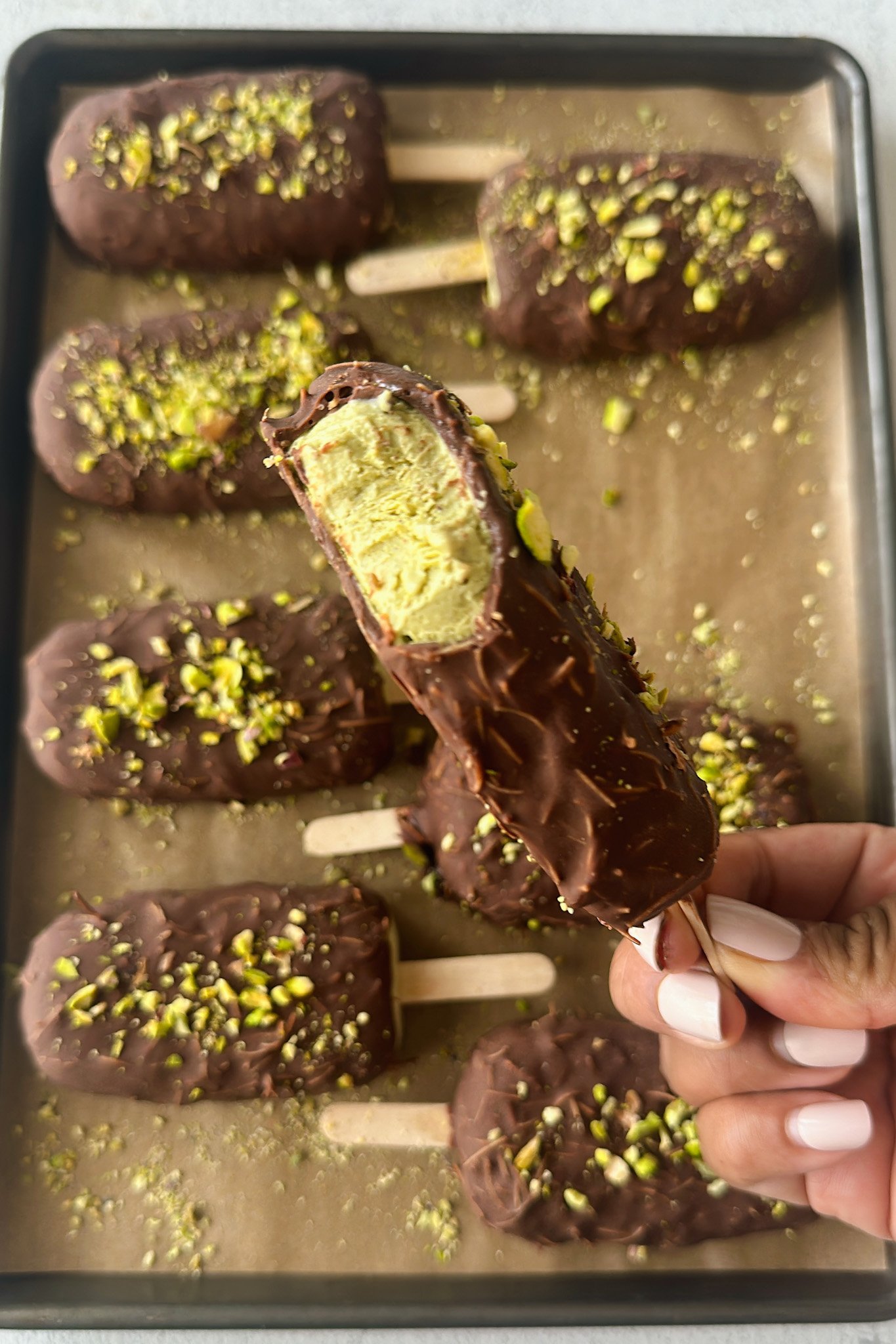 Pistachio ice cream bars on a baking sheet.
