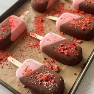 Frozen strawberry yogurt bars half dipped in chocolate.