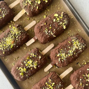 Pistachio ice cream bars on a baking sheet.