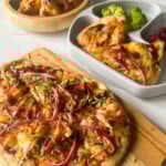BBQ chicken naan pizzas served with broccoli and cherries.