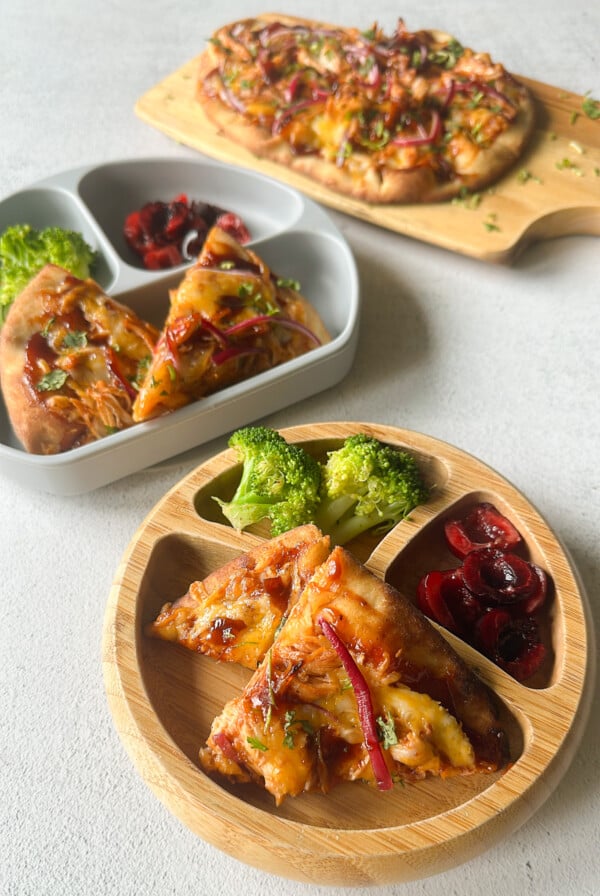 BBQ chicken naan pizzas served with broccoli and cherries.