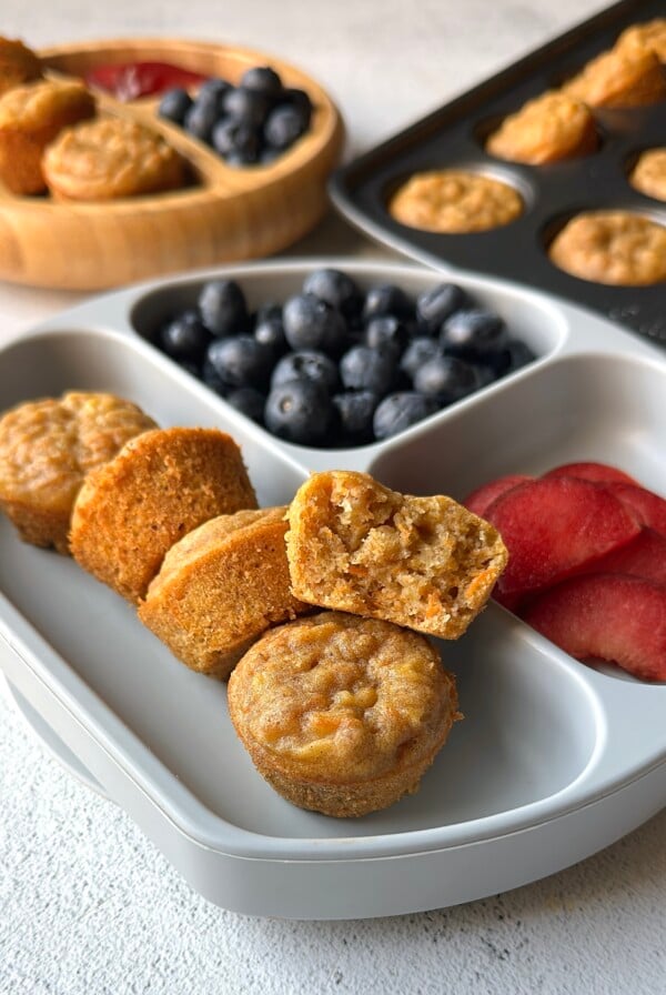 Banana carrot muffins served with blueberries and plums.