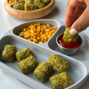 Broccoli tots served with ketchup, corn, and berries.